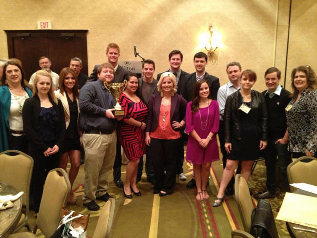 Mass Comm students at convention holding their trophy