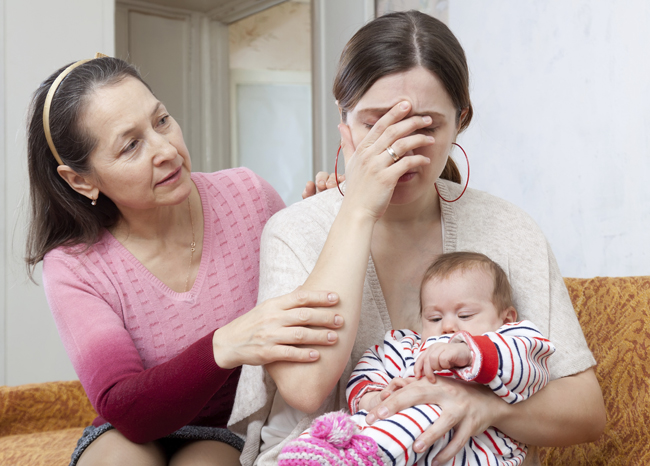 woman comforting another woman holding a baby