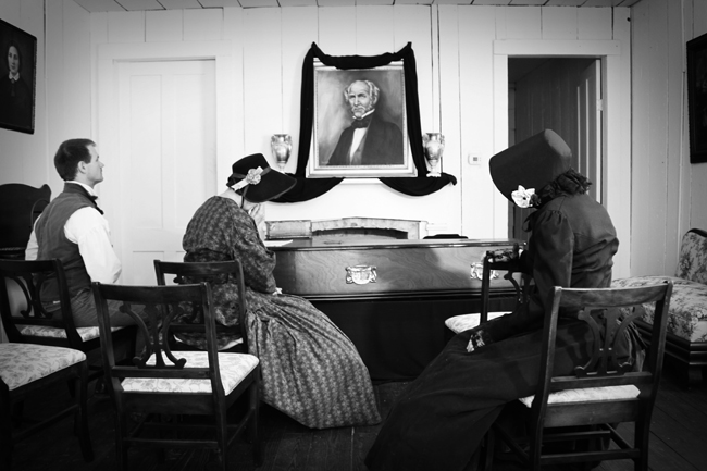 black and white photo if reenactors sitting around Sam Houston's coffin