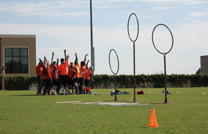 quidditch team huddling close to their three goal hoops on the practice field