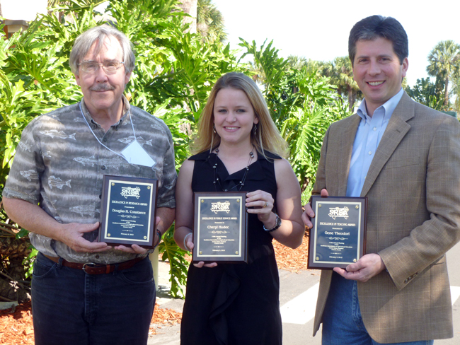 COnstance, Hudec, and Theodori holding their award plaques