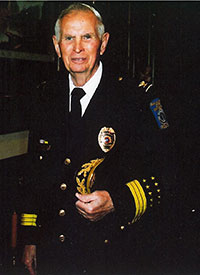 Tackett in formal uniform holding his hat