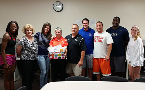 Thompson posing with students and coaches