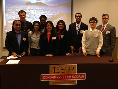 students posing behind Economics Scholars Program sign