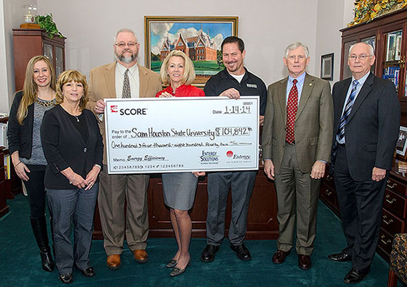 Entergy and Sam Houston State University emloyees standing with Dana Gibson holding a big check