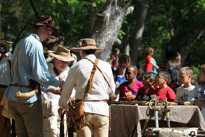participants dressed in period costumes demonstrating 19th century weapons