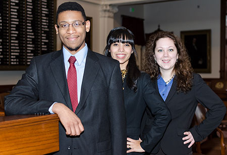 Interns Jeremiah Bailey, Jessica Oswald, and Bianca Kyle standing on the floor of the Texas House of Representatives