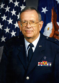 headshot of Hiram Jones in his Air Force uniform in front of the American and Air Force flags