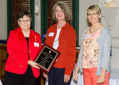 staff from the Newton Gresham Library pose with their award plaque