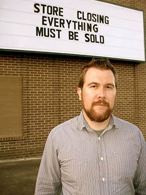Nick Lantz standing in front of a sign that says store closing everything must be sold