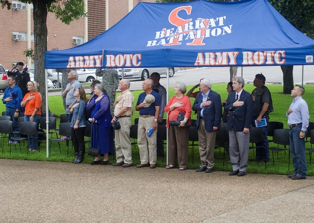 People under the ROTC booth putting their hands over their hearts