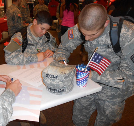 ROTC member writing letter to active serviceman