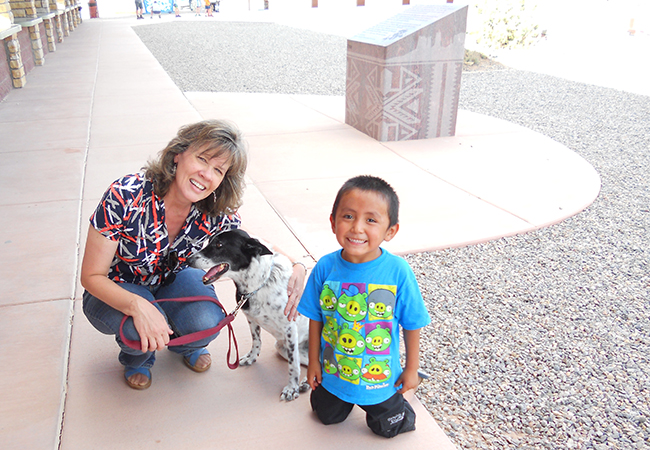 Valencia Browning-Keen kneeling next to her dog wih a young boy