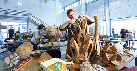 student working on cardboard sculpture