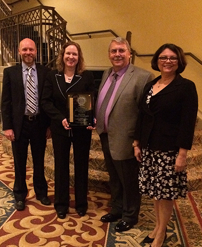 Wells, Bender, Morrison, and Montalvo posing with award