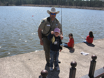 Ingram posing with children fishing