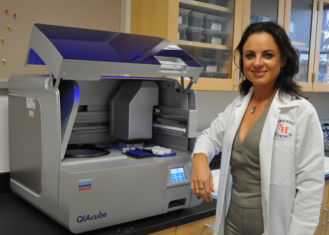 Hughes-Stamm standing at a lab machine