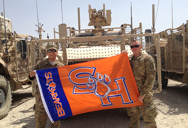 Leal and Meysembourg with SHSU flag in Afghanistan