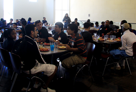 Shot of the lunchroom with students and staff at each table