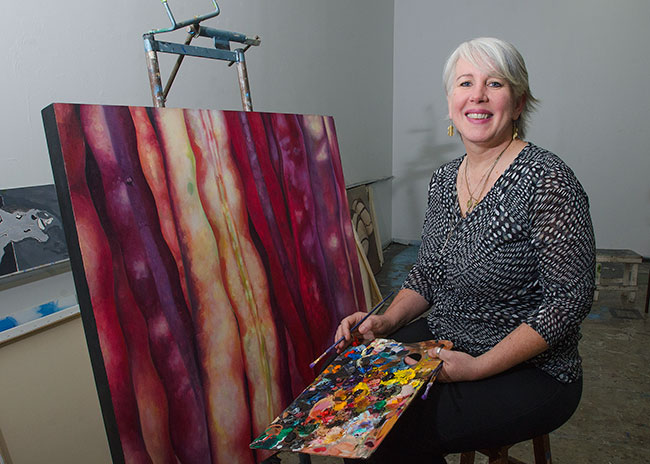 Edie Wells painting in her studio