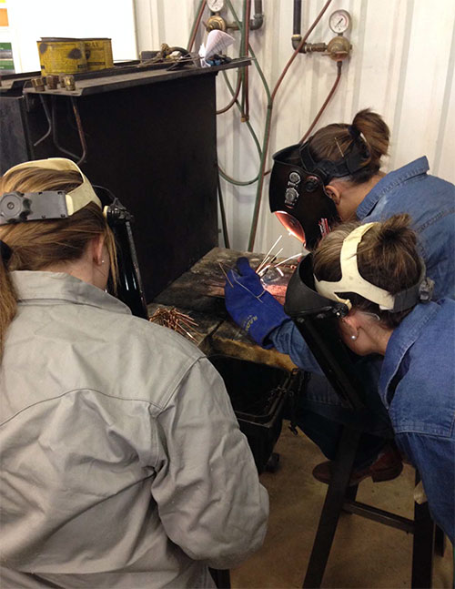 Feinberg posing while wearing her welding gear