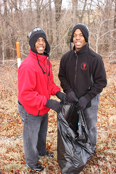 Darion and Varion holding a trash bag