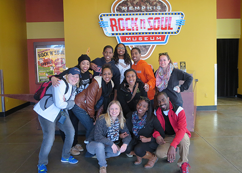 students posing in front of Rock and Roll Museum sign