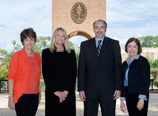 faculty standing in front of bell tower on campus