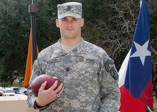 Watson posing in uniform with football